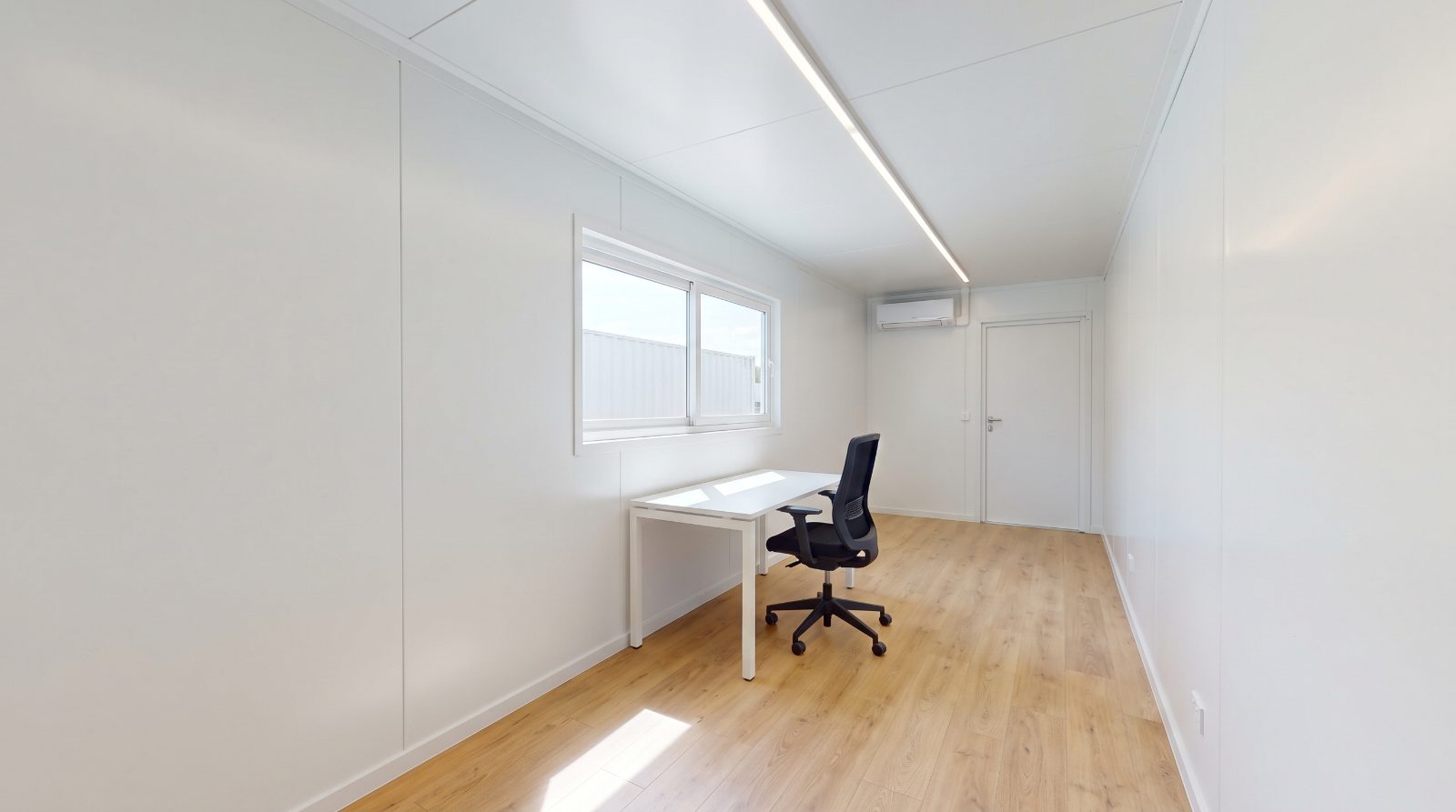 Finished shipping container office interior with desk, window and air conditioning